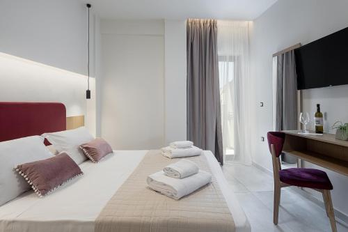 干尼亚Marron Lifestyle Hotel的白色卧室配有书桌和带毛巾的床