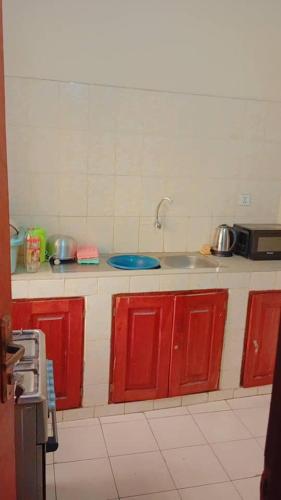 科托努BG archange的一间带红色橱柜和水槽的厨房