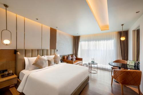 马杜赖Grand Madurai by GRT Hotels的卧室配有一张白色大床和一张书桌