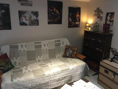 AnianeAu Rendez-Vous des Sorciers II的一间卧室配有一张床和一个梳妆台,墙上挂有图片