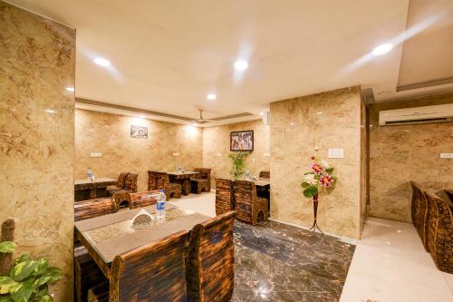 新德里Balwood Suites Near Delhi Airport的大房间设有石墙和桌椅