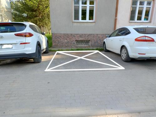 瓦尔米亚地区利兹巴克Nad Łyną的两辆白色汽车停在停车场