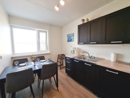 赖皮纳Räpina Apartment的厨房配有桌椅和水槽