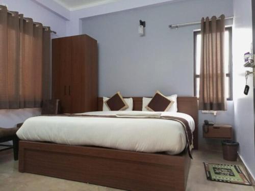 哈里瓦Hotel Prithvi Haridwar - Excellent Stay with Family, Parking Facilities的一间卧室配有一张带白色床单的大床