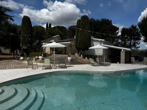 安德里亚Otto Apulia House B&B的房屋旁的游泳池配有椅子和遮阳伞