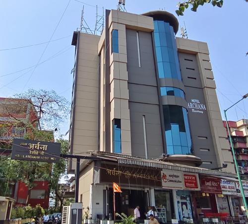 孟买HOTEL ARCHANA RESIDENCY的前方有街标的街道上的建筑物