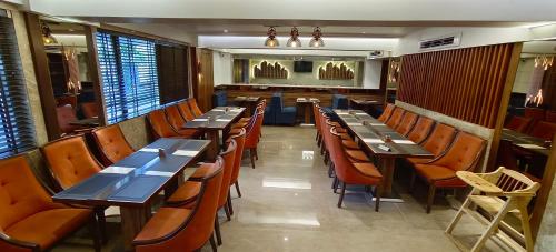 孟买HOTEL ARCHANA RESIDENCY的一间设有木桌和椅子的餐厅