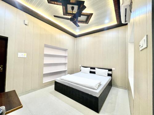 瓦拉纳西Hotel DEV VILLA GUEST HOUSE ! VARANASI fully-Air-Conditioned hotel at prime location, near Kashi Vishwanath Temple, and Ganga ghat的一间卧室配有一张床和吊扇