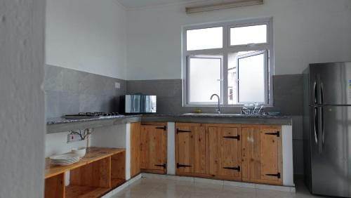 马蒂兰港Les Manglier的厨房配有木制橱柜和不锈钢冰箱。