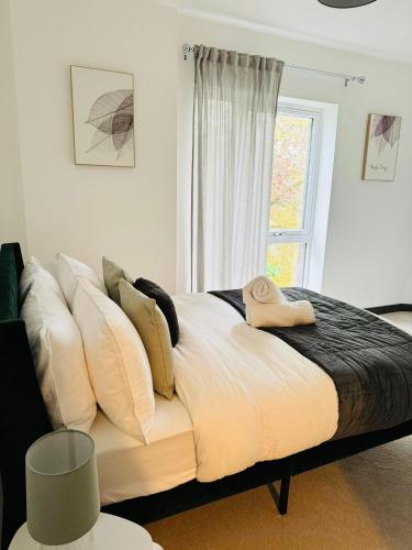 KentLuxurious & Spacious 2 Bed Apartment- Private Parking的一张带白色枕头的床和一个窗户