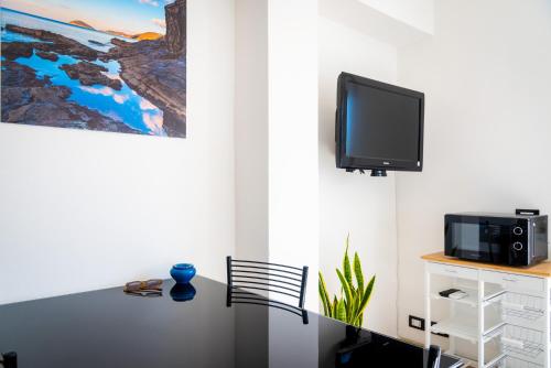 费拉约港Appartamento Il Mare e Dintorni的一间设有桌子的客房,墙上配有电视
