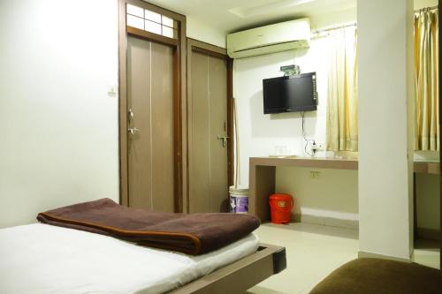 博帕尔Hotel Neelkanth , Bhopal的客房设有一张床和一台平面电视。