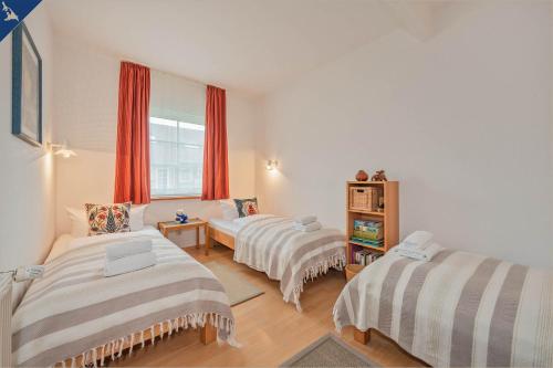 LütowLütow Ferienhaus an der Südspitze Gnitz的一间卧室设有两张床,窗户配有红色窗帘