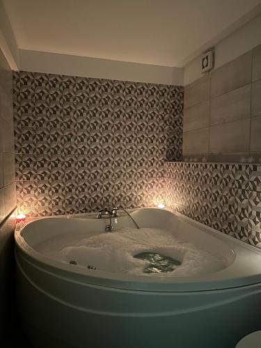 尼什Vila Storia的带浴缸的浴室和灯光