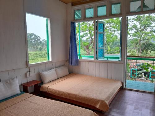 泉兰Mina Café & Stay的一间卧室设有两张床和两个窗户。