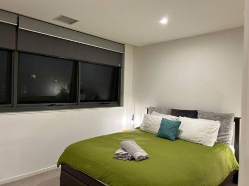 堪培拉Plush Apartment on Mort的一间卧室设有一张带窗户的绿色床