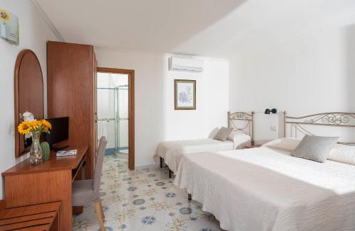 阿纳卡普里基拉索尔II号酒店的酒店客房设有两张床、一张桌子和一台电视。