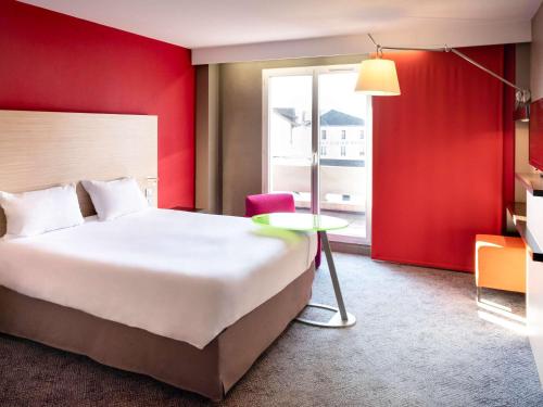 圣迪济耶圣迪济耶宜必思尚品酒店的酒店客房设有一张大床和一张桌子。