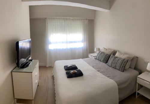 瓦伦西亚Apartamento centrico familiar en Valencia( Frente Estacion Ave ,Joaquin Sorolla)的一间白色卧室,配有床和电视