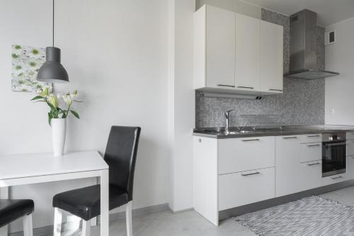 哥德堡Live and Stay Lagerbring的厨房配有白色橱柜、桌子和水槽。