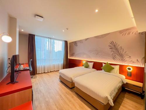 合艾Buri Sriphu Hotel & Convention Centre的酒店客房设有两张床和电视。