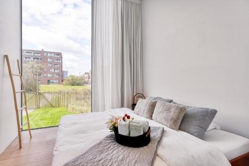 奥斯坦德Aimé aan zee, villa te Oostende - Oosteroever met 2 parkeerplaatsen的带沙发和大窗户的客厅