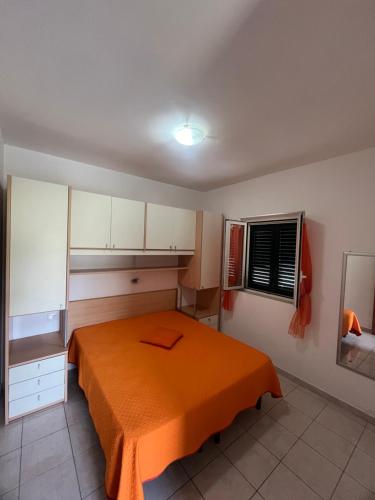 维耶斯泰Villa Angela case vacanza的一间卧室配有一张带橙色毯子的床