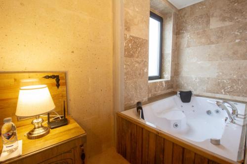 乌奇希萨尔Milagro of Cappadocia的一间带浴缸、灯和窗户的浴室