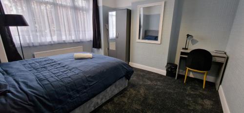 Streatham ValeRowan Crescent's Luxury Stay-In 2的一间卧室配有一张床、一张桌子和一把椅子