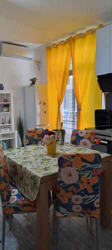 GhirodaSweet Lemon Home的厨房配有桌椅和黄色窗帘