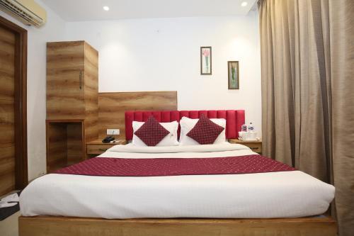 阿姆利则Hotel RV Regency的一间卧室配有一张大床和红色床头板