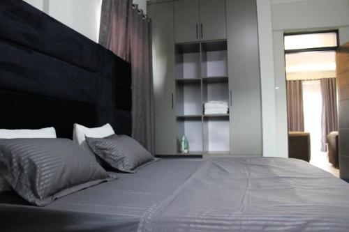 MunyonyoMHP Apartments的一间卧室配有一张大床和大床头板