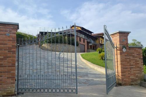 迪亚诺达尔巴Casa Castella - Adults Only - Langhe的车道的大门,车道后面有建筑物