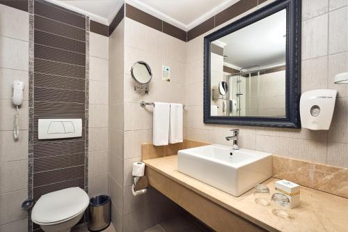 克孜拉阿奇Seaden Sea World Resort & Spa的一间带水槽、卫生间和镜子的浴室