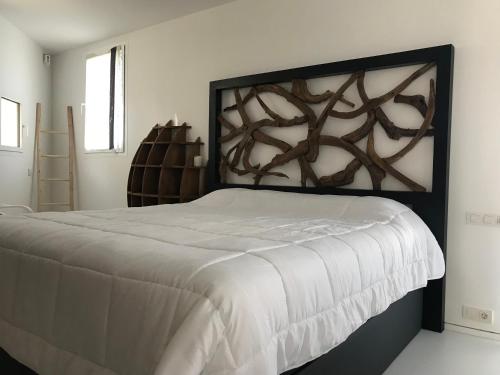 伊维萨镇LA MAISON BLANCHE IBIZA 5*的一间卧室配有一张大床和木制床头板