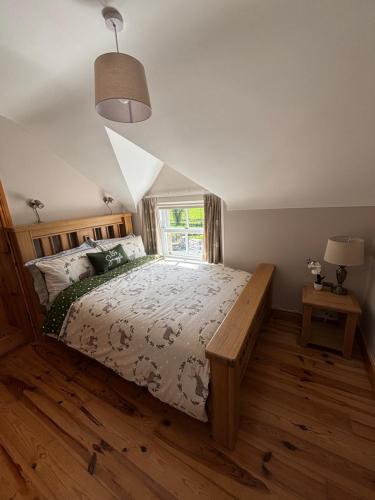 五英里镇The Old Barn的一间卧室设有一张大床和一个窗户。