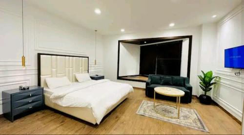拉合尔Premium 1BR DHA Phase 5的卧室配有一张白色大床和一把椅子