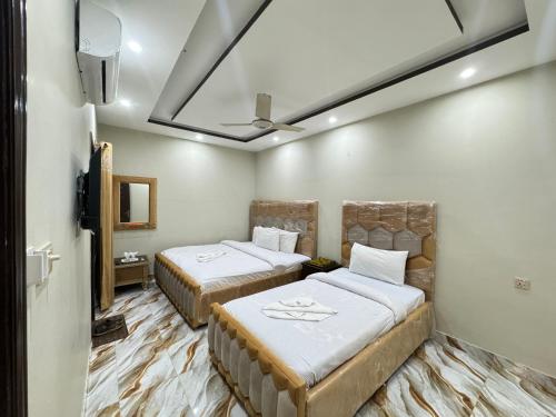 伊斯兰堡Decent Lodge Guest House F-10的客房设有两张床和吊扇。