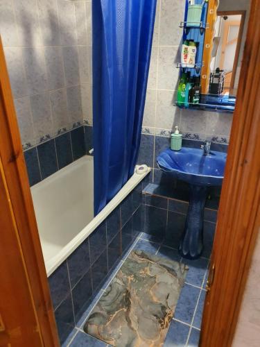 阿克套Уютная квартира в центре города.的浴室配有水槽和淋浴间,地板受损
