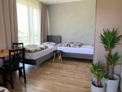 利波瓦Apartamenty Nad Zimnikiem的小房间设有两张床、一张桌子和一张桌子