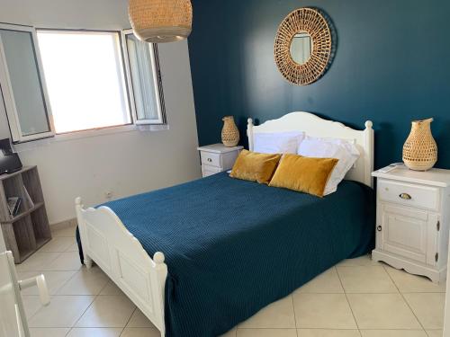 利勒鲁斯T2 clim 54m2, 17m2 de terrasse très belle vue mer的一间卧室配有一张蓝色墙壁的床