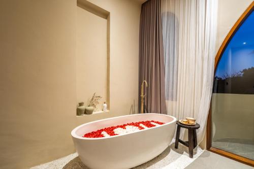 坎古Amani Villas: New, Luxury, Mediterranean, Private Pool, Canggu的浴室设有装满红色鲜花的白色浴缸