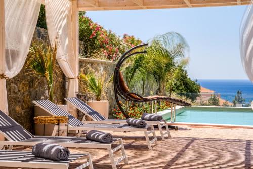 吉奥塔略Heliophos Villa Aelia的一个带椅子的庭院和一个游泳池
