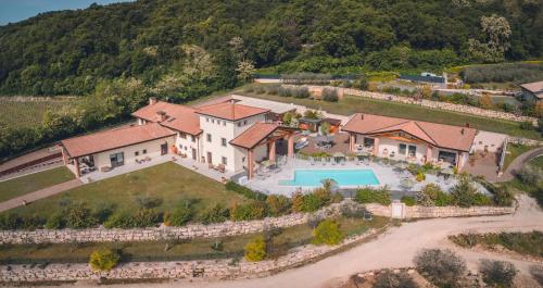 科斯特曼诺Agriturismo La Pertica的享有带游泳池的房屋的空中景致