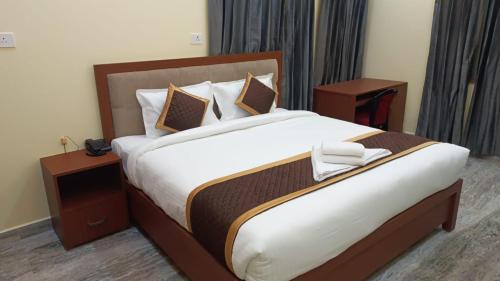 瓦拉纳西Hotel Kashyaam Inn的一间卧室配有一张带2个床头柜的大床