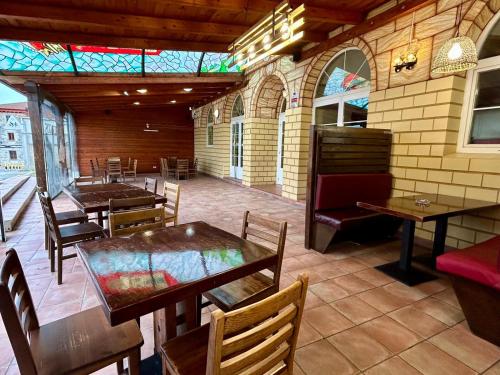 Villalbilla de BurgosHOSTAL-RESTAURANTE POSADA DEL DUQUE的餐厅设有桌椅和彩色玻璃天花板