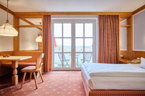 兰格劳塞霍夫斯特兰德酒店的酒店客房设有一张床铺、一张桌子和一个阳台。