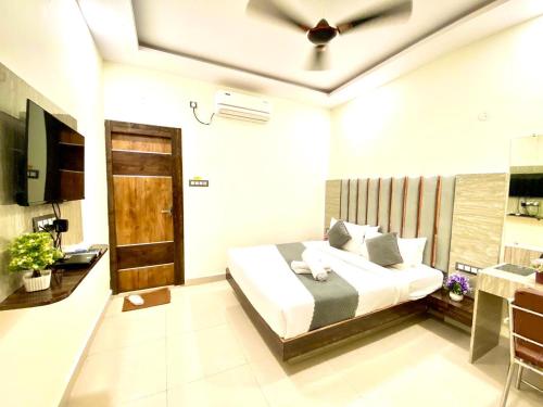 商沙巴Hotel Sky International- Airport Zone Hyderabad的一间卧室配有一张床和一台电视