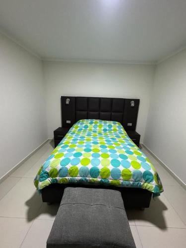 苏克雷Departamento céntrico en la ciudad de Sucre的一张带五颜六色的被子的床