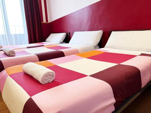 马德里广场之家旅馆的一张多彩毯子房间里的床